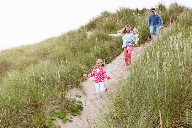 istock Family Running Through Sand Dunes Together 510080770