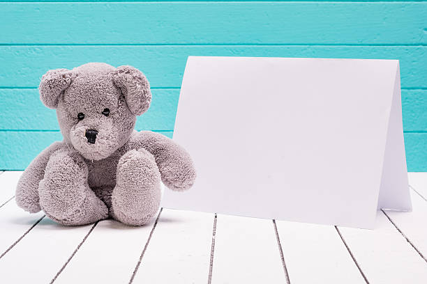 istock Teddy bear sitting on white wooden floor in blue-green 510080796