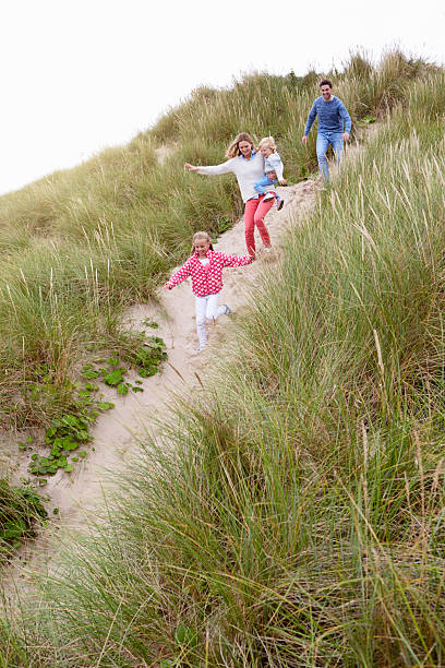istock Family Running Through Sand Dunes Together 510080884