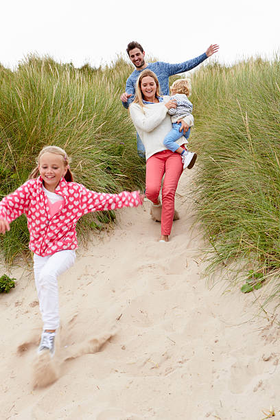 istock Family Running Through Sand Dunes Together 510080976
