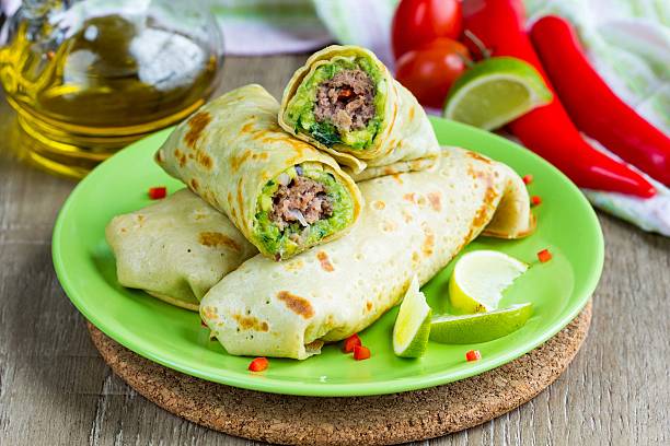 Pancakes stuffed with avocado sauce, meat beef kebab, Mexican ro stock photo