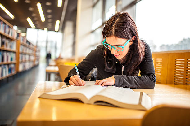 istock Young Woman Studying in Public Library 510085770