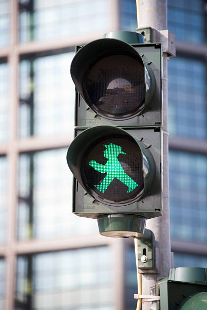 Green pedestrian traffic light, Berlin Berlin, Germany - August 8, 2014: Green pedestrian traffic light with the Ampelmann of East Germany ampelmännchen photos stock pictures, royalty-free photos & images