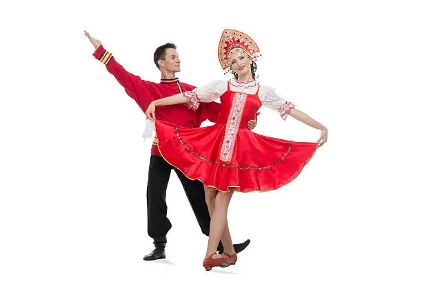 Couple of dancers in russian traditional costumes, girl in red sarafan and kokoshnik, boy in black trousers and red shirt . Studio shot isolated on white.