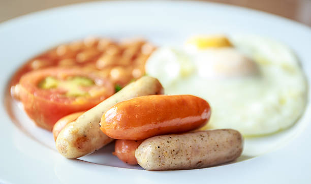 istock English breakfast with sausages, fried eggs, tomato, and bean 510129435