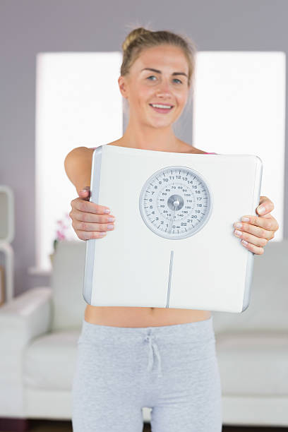 istock Sporty cheerful blonde holding scales 510132347