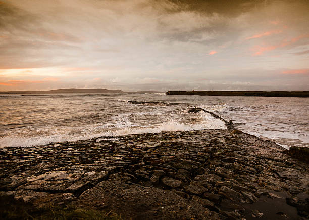 The setting summer sun over calm seas in Dorset UK