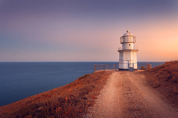 istock Beautiful white lighthouse on the ocean coastline at sunset. Landscape 510151098