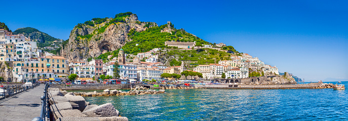 Panoramic picture-postcard view of the beautiful town of Amalfi at famous Amalfi Coast with Gulf of Salerno on a sunny day with blue sky in summer, Campania, Italy.