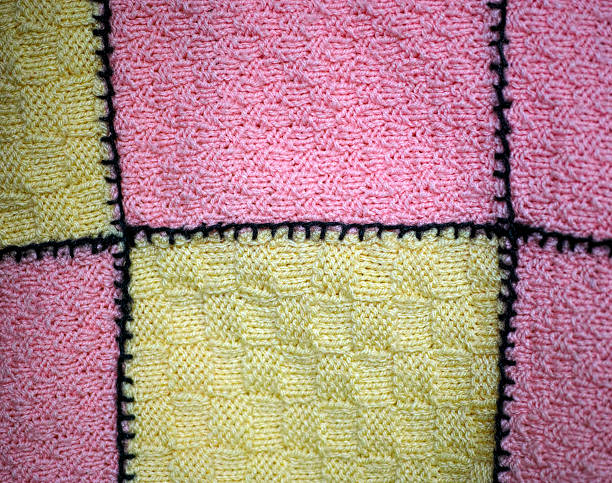 Background of pink and yellow hand knitted blanket