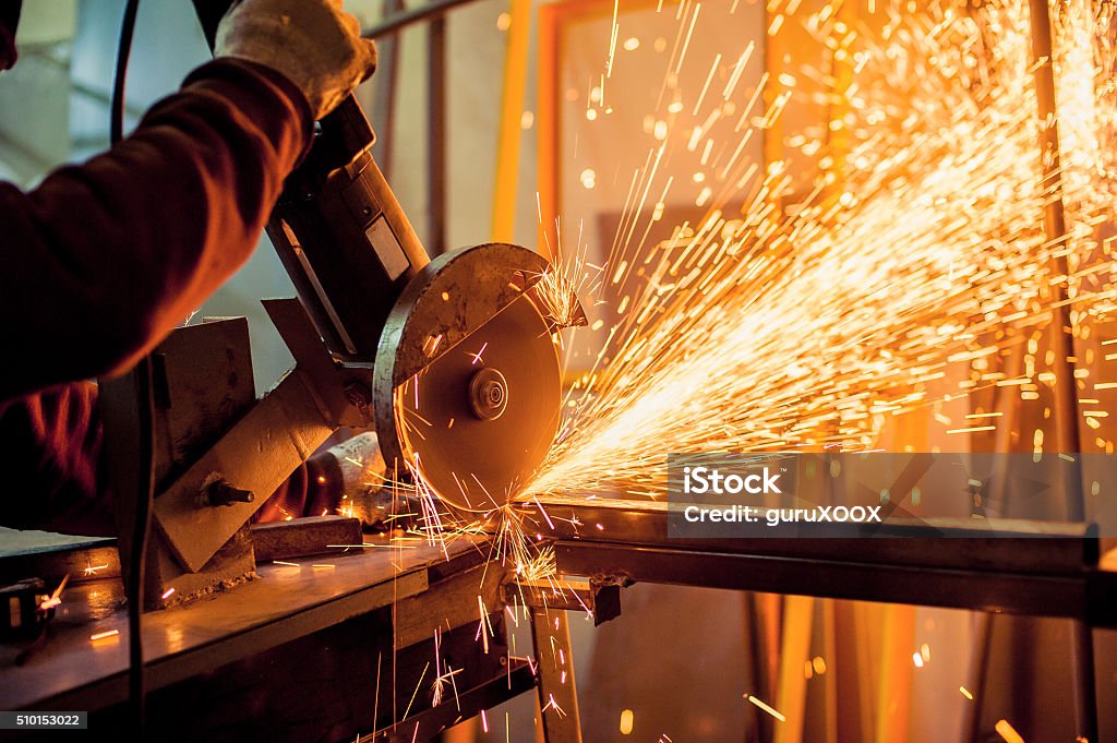 Electric grinder A man working with electric grinder tool  on steel structure in factory, sparks flying Metal Stock Photo