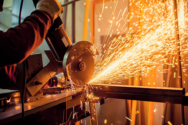 Electric grinder A man working with electric grinder tool  on steel structure in factory, sparks flying cutting stock pictures, royalty-free photos & images