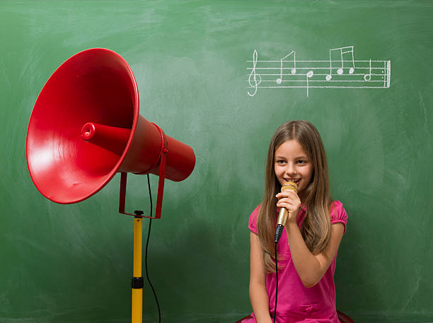 istock Little girl directing chorus for music before blackboard 510153711