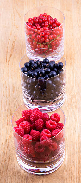 istock Black, red currants and raspberries in glasses 510155429