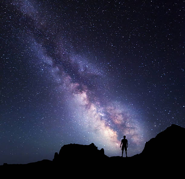 istock Milky Way. Night sky and silhouette of a standing man 510155768