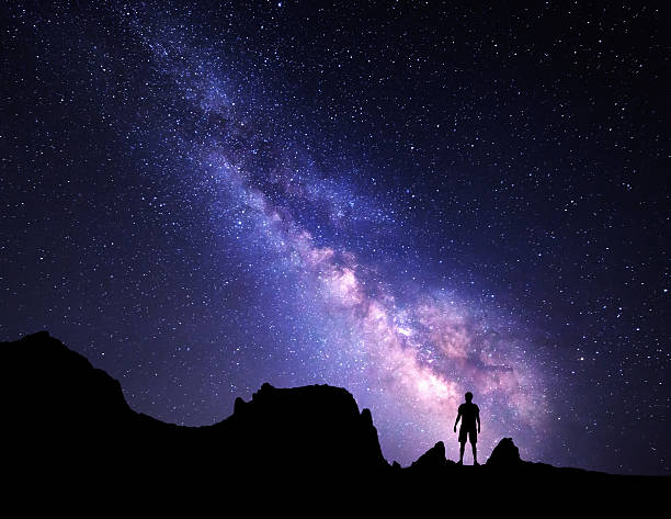 istock Milky Way. Night sky and silhouette of a standing man 510155838