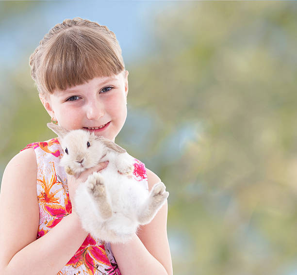 istock laughing girl holding a rabbit. 510156409