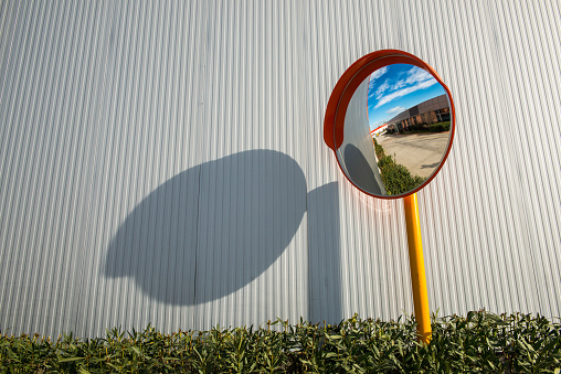 Convex mirror showing the streets in front of a factory
