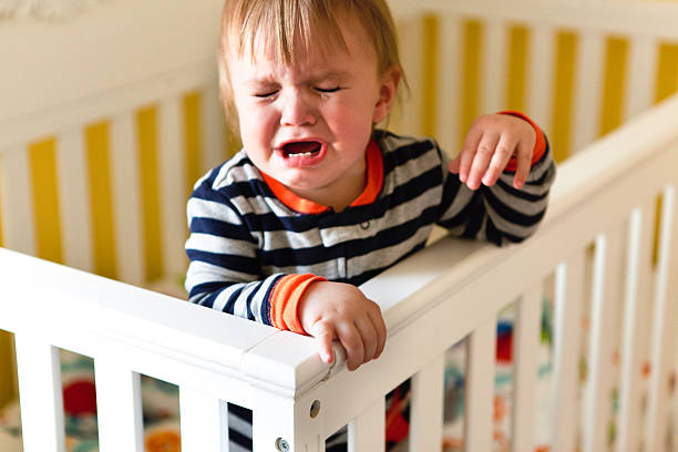 Baby Crying in Crib 12 month old baby is crying in crib. tantarum in babies stock pictures, royalty-free photos & images