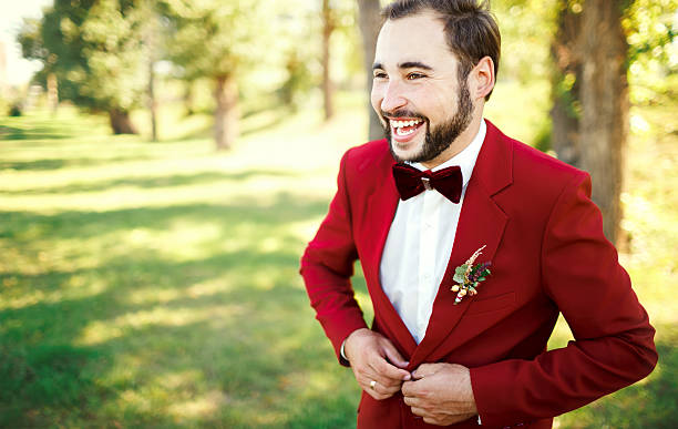 Stylish groom in tuxedo laughs suit marsala red, burgundy bow stock photo