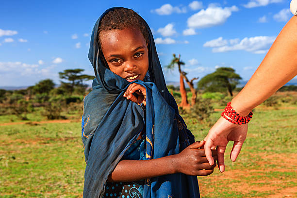 Caucasian female is holding young african child's hand Caucasian female is holding young african child's hand in Ethiopian village.http://bem.2be.pl/IS/ethiopia_380.jpg ethiopia photos stock pictures, royalty-free photos & images