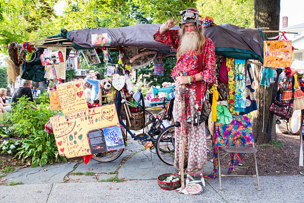 Grandpa Woodstock, Woodstock NY Woodstock, New York, USA - August 30, 2015:  Hippie, Allyn Richardson, also known as Grandpa Woodstock, poses for photograph outside tent sale in Woodstock New York. Grandpa Woodstock is well-known in this artistic Ulster County town, best known for lending its name to the Woodstock festival of 1969  woodstock stock pictures, royalty-free photos & images