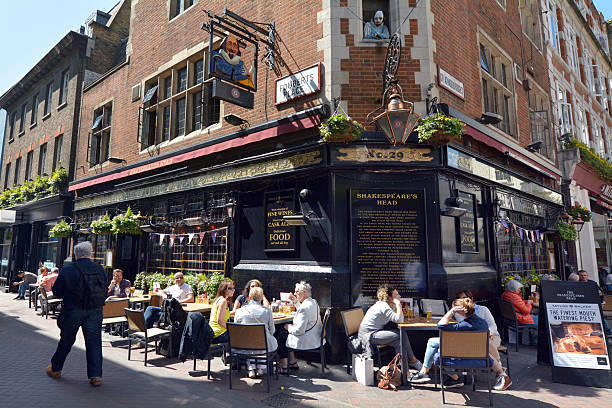 London, United Kingdom - May 14, 2015: People drink at Shakespeares Head pub in Carnaby Street London UK. Carnaby Street is a popular pedestrianized shopping street in the City of Westminster, London