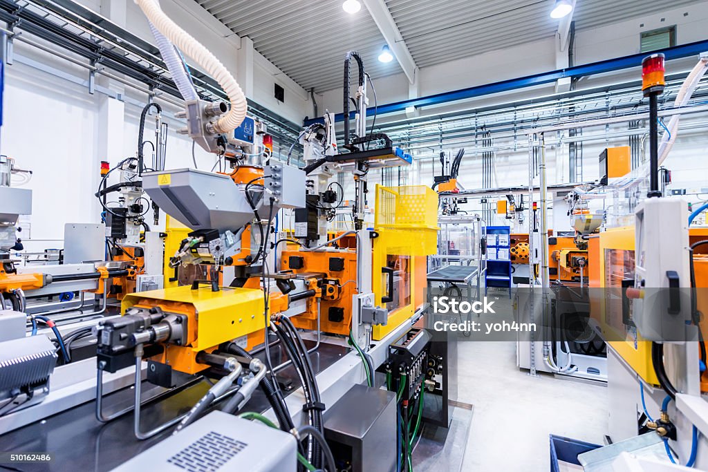 Production line of plastic industry Horizontal color image of large group of automated injection moulding machines for plastic parts production. Industry Stock Photo