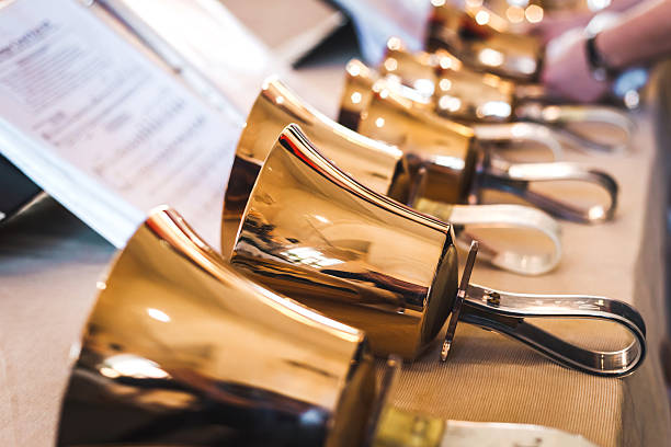 Handbells on table ready to perform Golden handbells on table with sheet of notes choir photos stock pictures, royalty-free photos & images