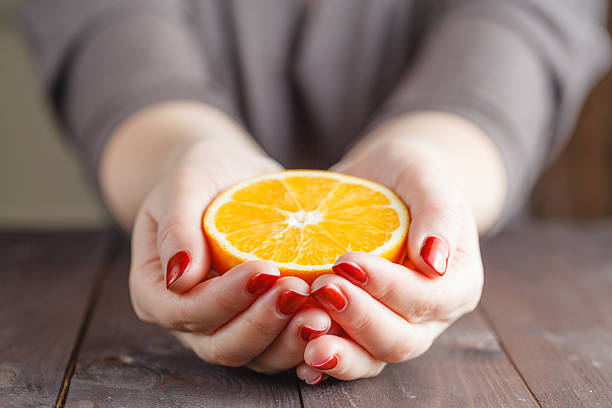 istock Woman hands holding one half orange 510164796