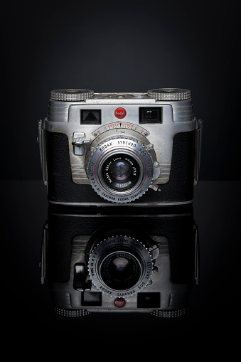 Woodbridge, New Jersey, USA - February 20, 2014: A Kodak Signet camera with an Ektar Lens sits on a black reflective surface; this camera was marketed from 1951-1958, took 135 film, and retailed for $95 US dollars