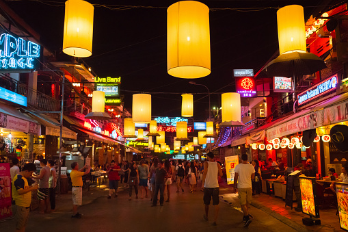 Siem Reap, Cambodia - January 5, 2016: Crowd of Tourists, Backpackers and Travellers walking along the famous illuminated downtown Pub Street packed with Bars, Hotels, Restaurant and Shops at Night. Pub Street Nightlife, Siem Reap, Cambodia.