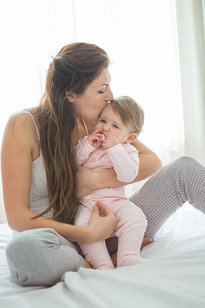 istock Happy momy huging her daughter on morning bed 510173812