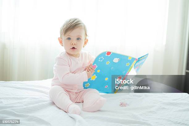 Litle Innocent Baby Reading Book On Bed Stock Photo - Download Image Now - Baby - Human Age, Book, Child