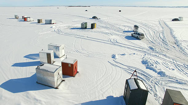 pesca sobre hielo congelado campamento aldea lago en invierno - winnebago fotografías e imágenes de stock