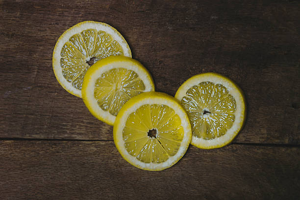 istock Four Lemon Slices on Wood Background 510176136