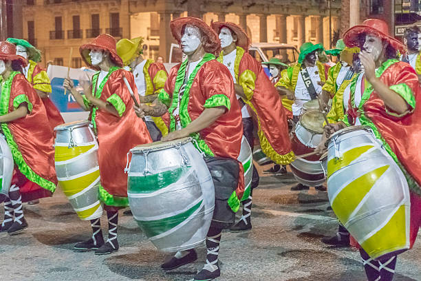 Montevideo, Uruguay - January 22,  2016 : Costumed men drummers playing traditional music called candombe at the inaugural parade of carnival of Montevideo, Uruguay