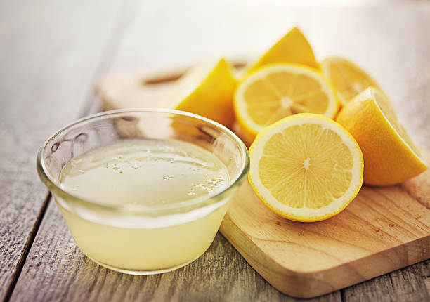 lemon juice freshly squeezed lemon juice in small bowl Lemon Juice stock pictures, royalty-free photos & images