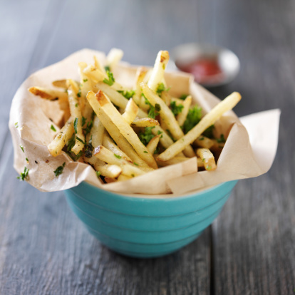 truffle fries standing up in a bowl with wax paper lining shot close up