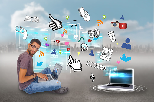 Digital composite of casual man using laptop with app icons