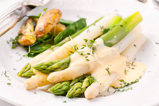 Asparagus with Potatoes Asparagus with potatoes as closeup on a white plate fork silverware table knife fine dining stock pictures, royalty-free photos & images