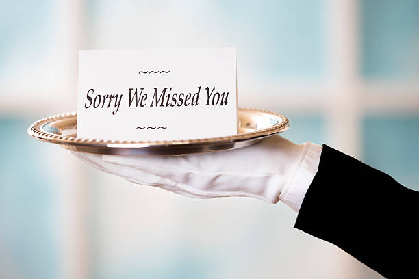 Butler holds "Sorry We Missed You" notecard on silver platter. White gloved hand in formal black suit holds "Sorry We Missed You" notecard on a silver platter.  Daytime window background.  See more like this image with numerous notecard messages, backgrounds in lightbox below. silver platter stock pictures, royalty-free photos & images