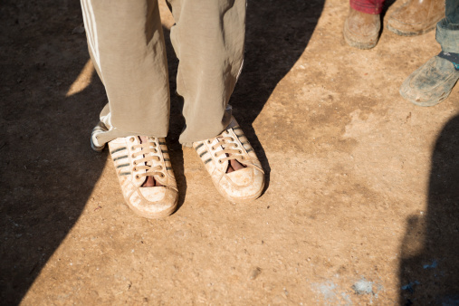 Atmeh, Syria - January 14, 2013: A Syrian refugee stands with shoes but no socks outside his tent at the camp for displaced persons in Atmeh, Syria, which is located adjacent to the Turkish border. He fled violence near his home in Idlib Province.