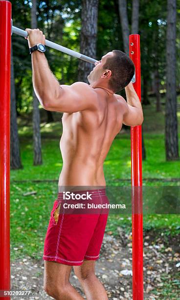 Muscular Man Haciendo Pullups Foto de stock y más banco de imágenes de 20-24 años - 20-24 años, Actividad, Actividades recreativas