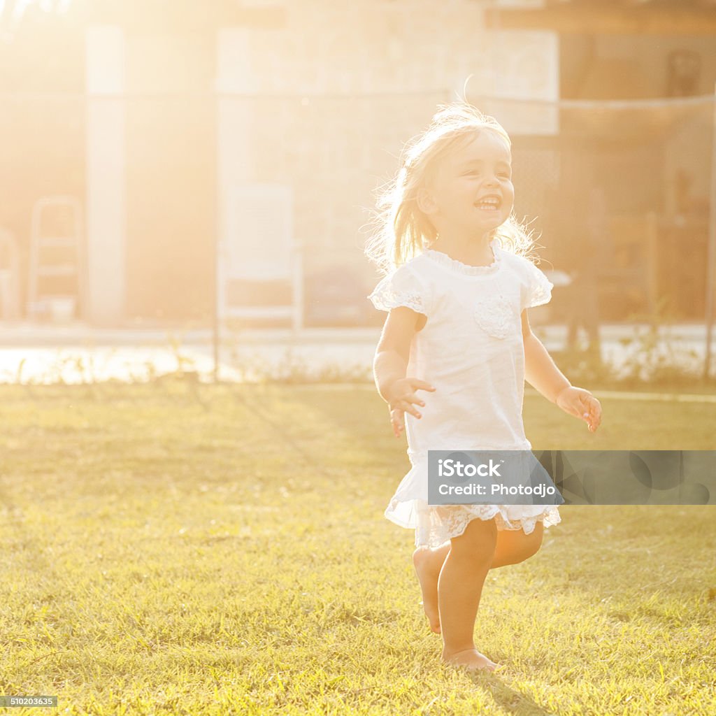 Cheerful child Happy little girl running in the yard 2-3 Years Stock Photo