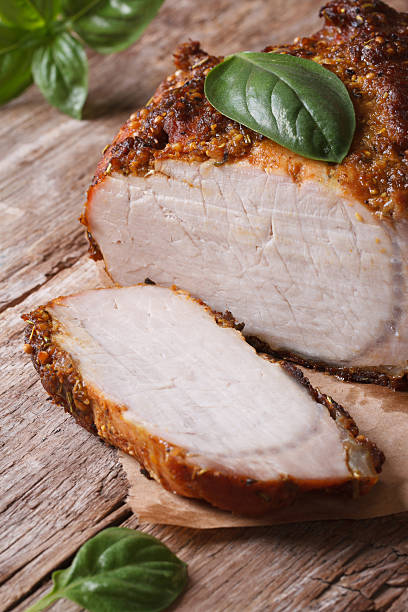 istock Sliced roast pork tenderloin and basil close-up vertical 510205273