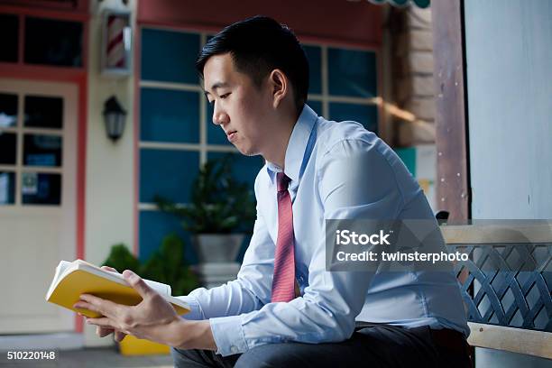 Asian Man Reading A Book Sitting On Bench Stock Photo - Download Image Now - Adult, Asian and Indian Ethnicities, Beautiful People