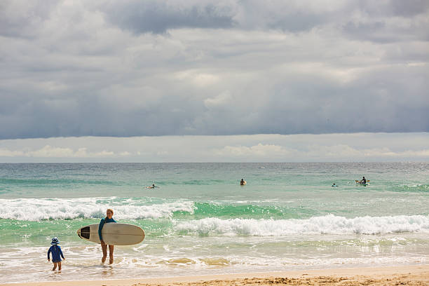 istock Female Surfer With a Child at Beach 510220818