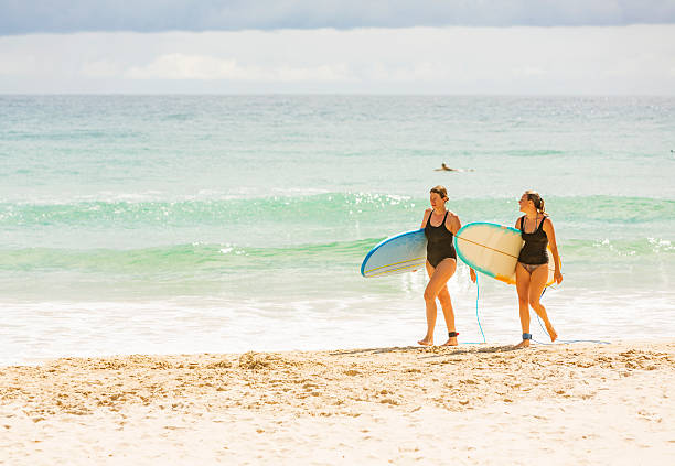 duas mulheres de regressar de surf na praia - cabarita beach imagens e fotografias de stock