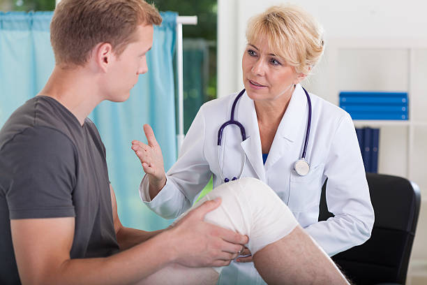 Doctor talking with patient Doctor talking with patient having trauma of patella human joints medical stock pictures, royalty-free photos & images